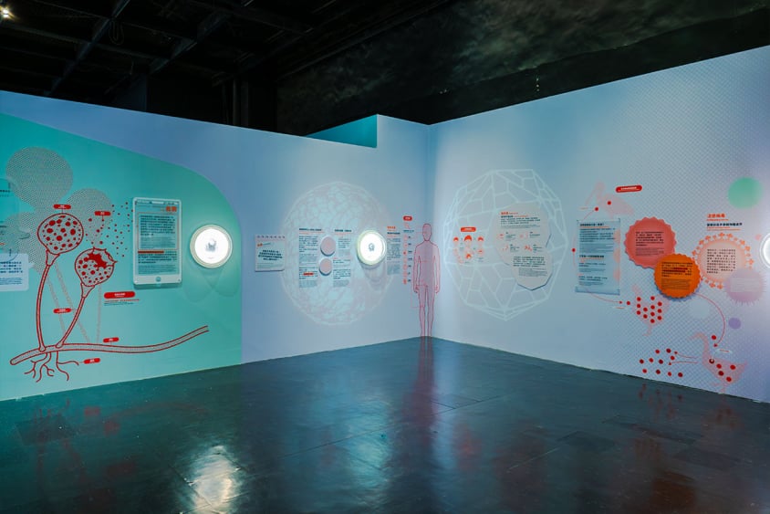 「看見你我他牠它」特展第二區「微觀世界」，藍色展牆展示真菌與病毒圖文說明及發光觀察窗
