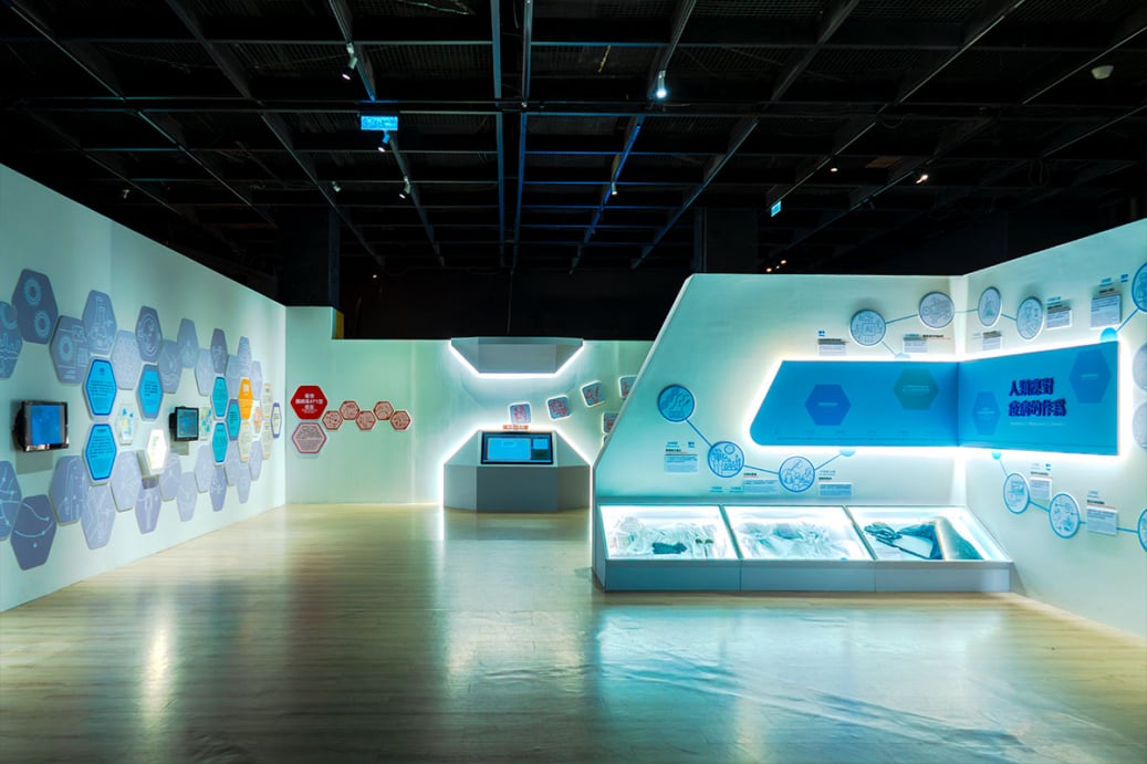 「看見你我他牠它」特展展區全景，展示「人類應對疾病的作為」主題展牆與六角形圖文板