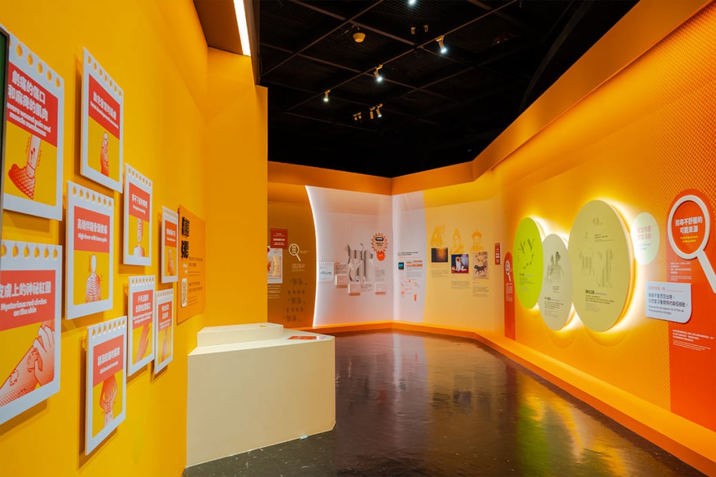 「看見你我他牠它」特展第一區「我們的鄰居」，黃色展廊展示症狀圖文卡與圓形發光展板